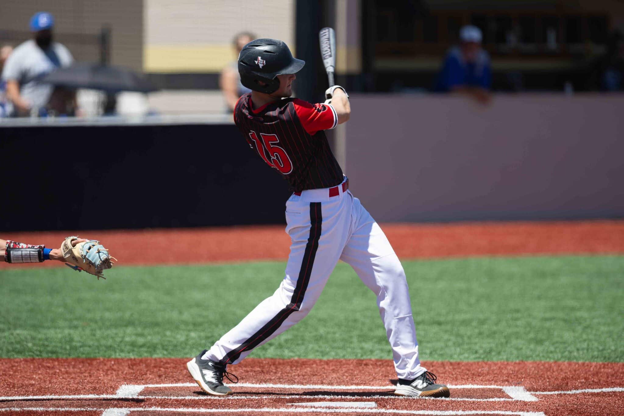 Baseball player in a black helmet and red pinstripe jersey swinging a bat at a pitch in a game batter's box.