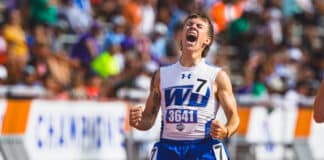 Male sprinter crosses the finish line, shouting in celebration, wearing white-blue uniform and bib 3641 on a track.
