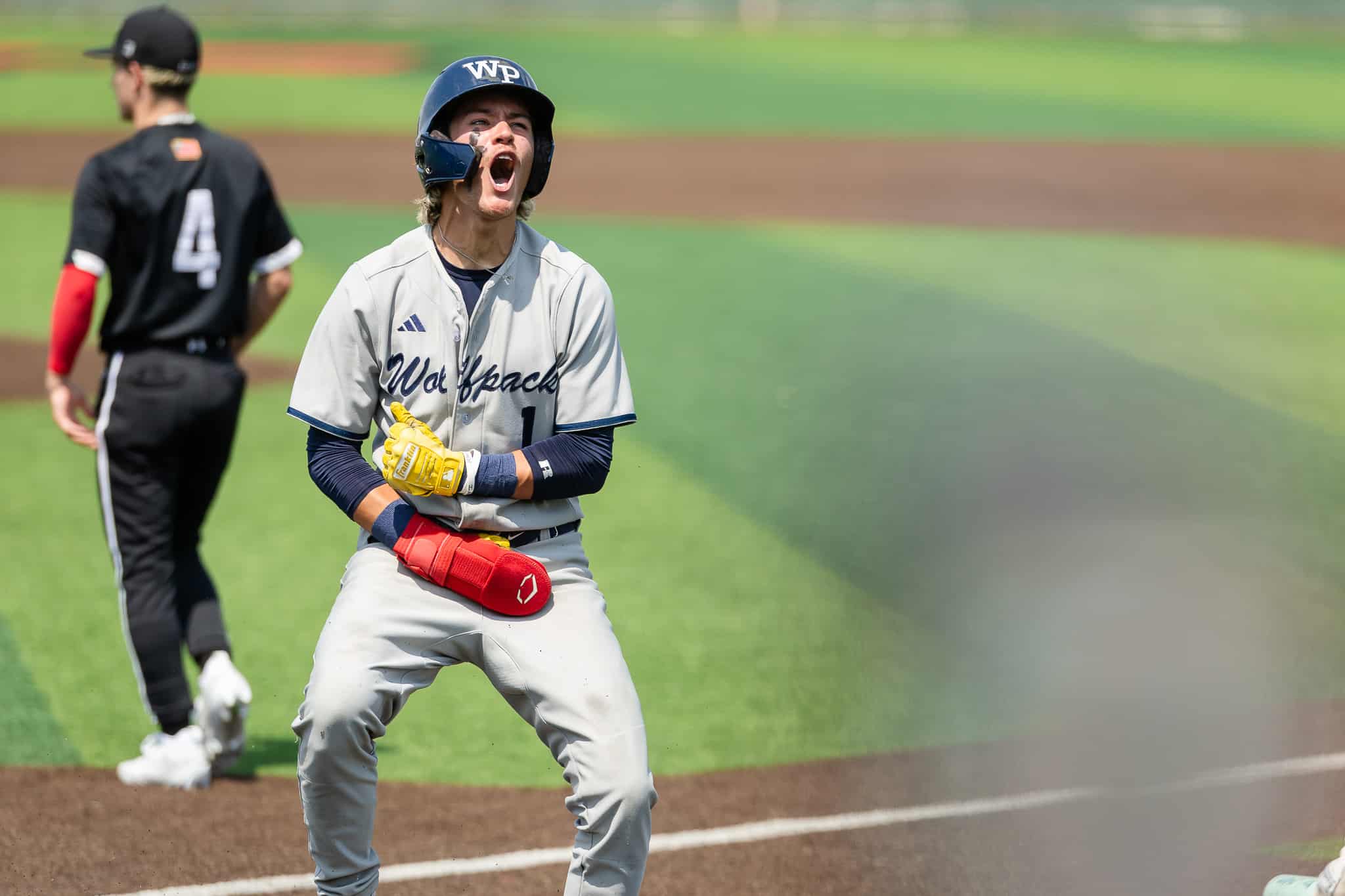 west-plains-baseball-jpegJoe-pps-7 | Press Pass Sports Baseball catcher in gray uniform shouts with mouth wide open on the field, wearing a helmet and yellow glove.