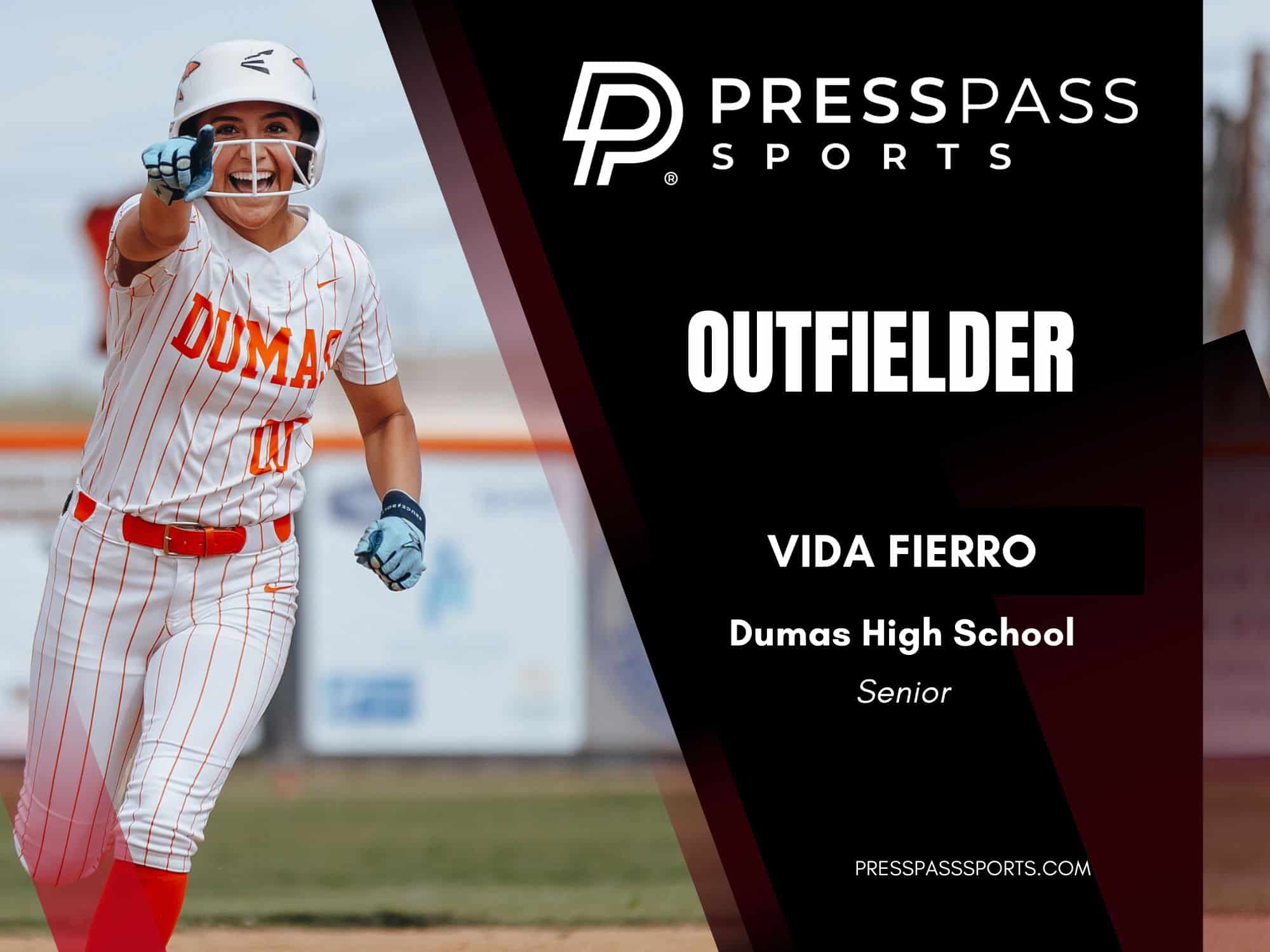 2026 Softball Team of the year 13 | Press Pass Sports Softball player in a white pinstripe uniform and helmet, pointing at the camera with a smile as a banner on the right introduces'Outfielder Vida Fierro'.