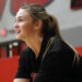 1K6A5057 | Press Pass Sports Woman in a gym, side profile with blonde ponytail, wearing a black top, captured in mid-action against a red and gray background.