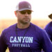 1K6A8625 | Press Pass Sports Man in purple Canyon Football shirt with cap and sunglasses, on a field with another player blurred in background at sunset.