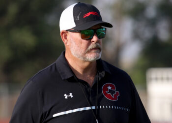 Gruver - HC Kurt Haberthur 2 | Press Pass Sports Man outdoors wearing a black polo with white stripes, a cap, and reflective sunglasses, looking off to the right.