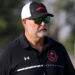 Gruver - HC Kurt Haberthur 2 | Press Pass Sports Man outdoors wearing a black polo with white stripes, a cap, and reflective sunglasses, looking off to the right.