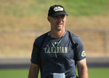 1K6A1920 | Press Pass Sports Coach outdoors wearing a navy CANADIAN shirt, black cap, and lanyard.