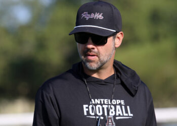 Abernathy - HC Keith Bloskas 1 | Press Pass Sports Man in black cap and sunglasses outdoors, wearing a black shirt that reads 'ANTELOPE FOOTBALL' on the front.
