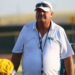New Deal - HC Matt Hill 2 | Press Pass Sports Coach wearing a white polo and cap with sunglasses stands on a football field, yellow helmet visible to the left.