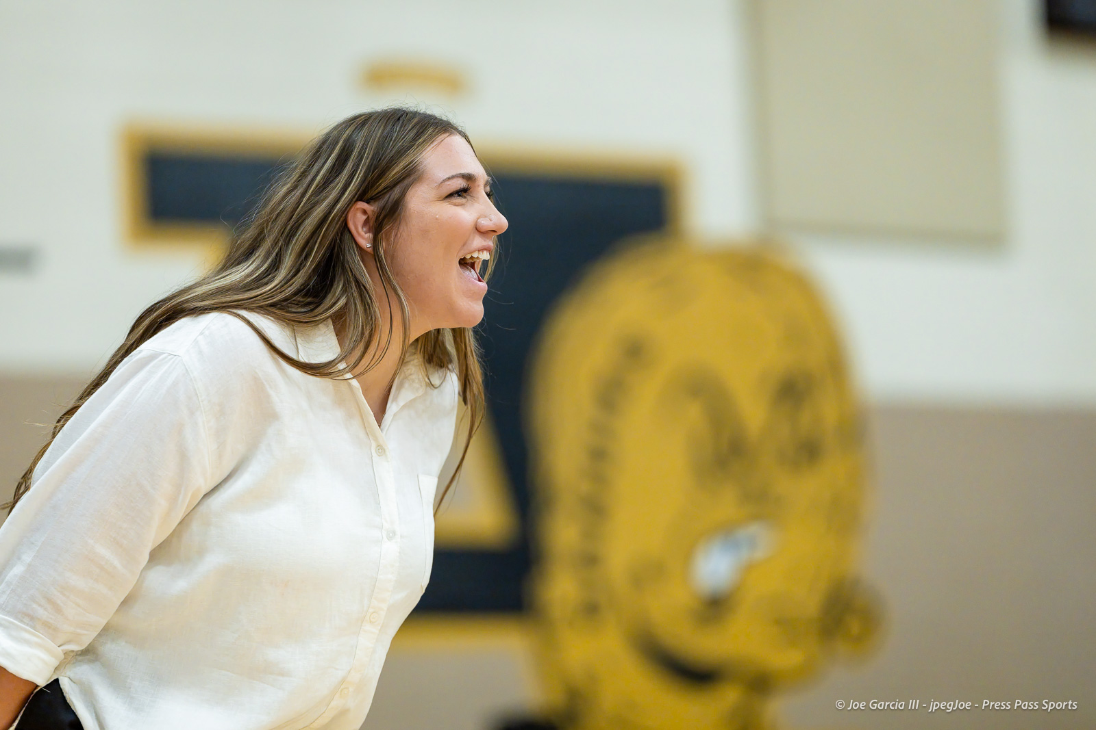 west-plains-vs-amarillo-high-2026-jpegJoe-pps-4 | Press Pass Sports Woman in a white shirt laughing, leaning forward in an indoor gym or hall.