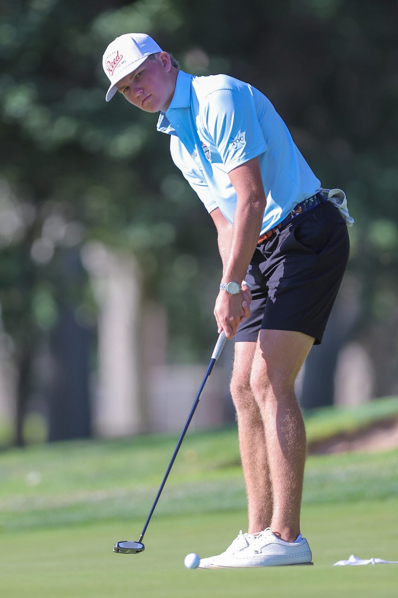 20260813-CoorsTOC-Day1-060 | Press Pass Sports Male golfer wearing a light blue polo and white cap preparing to putt on a sunny golf course