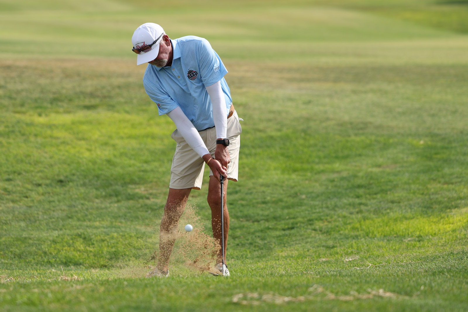 CoorTOC_FinalDay-7 | Press Pass Sports Male golfer in a light blue polo and cap hits a shot from a sand bunker on a green golf course