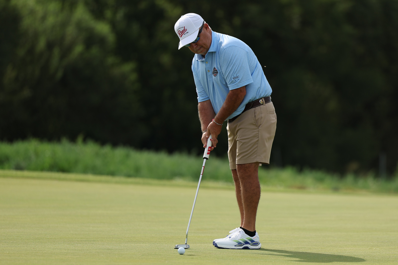 CoorTOC_FinalDay-16 | Press Pass Sports Golfer in a light blue polo and khaki shorts putting on a green golf course.
