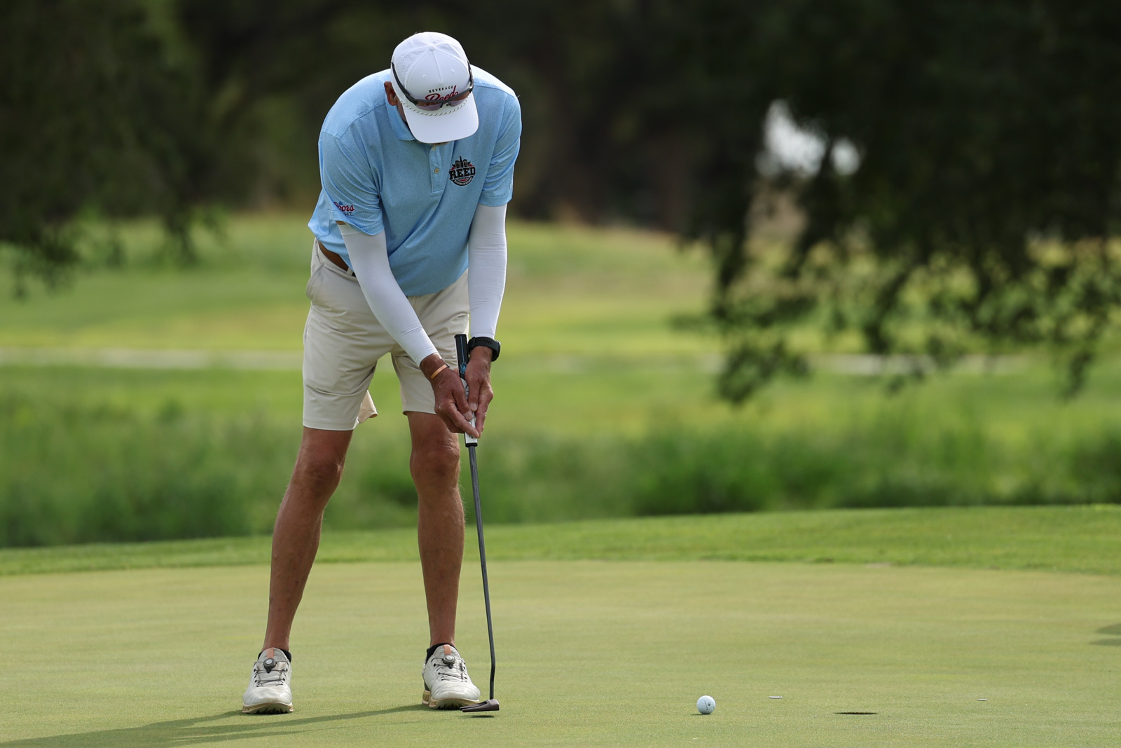 CoorTOC_FinalDay-21 | Press Pass Sports Golfer bending to line up a putt on a green with a putterball approaching the hole.