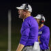 CHS-WPHS-FB-31 2 | Press Pass Sports Coach in a white cap and purple shirt wearing a headset, with a clipboard tucked in his pocket during a night practice.