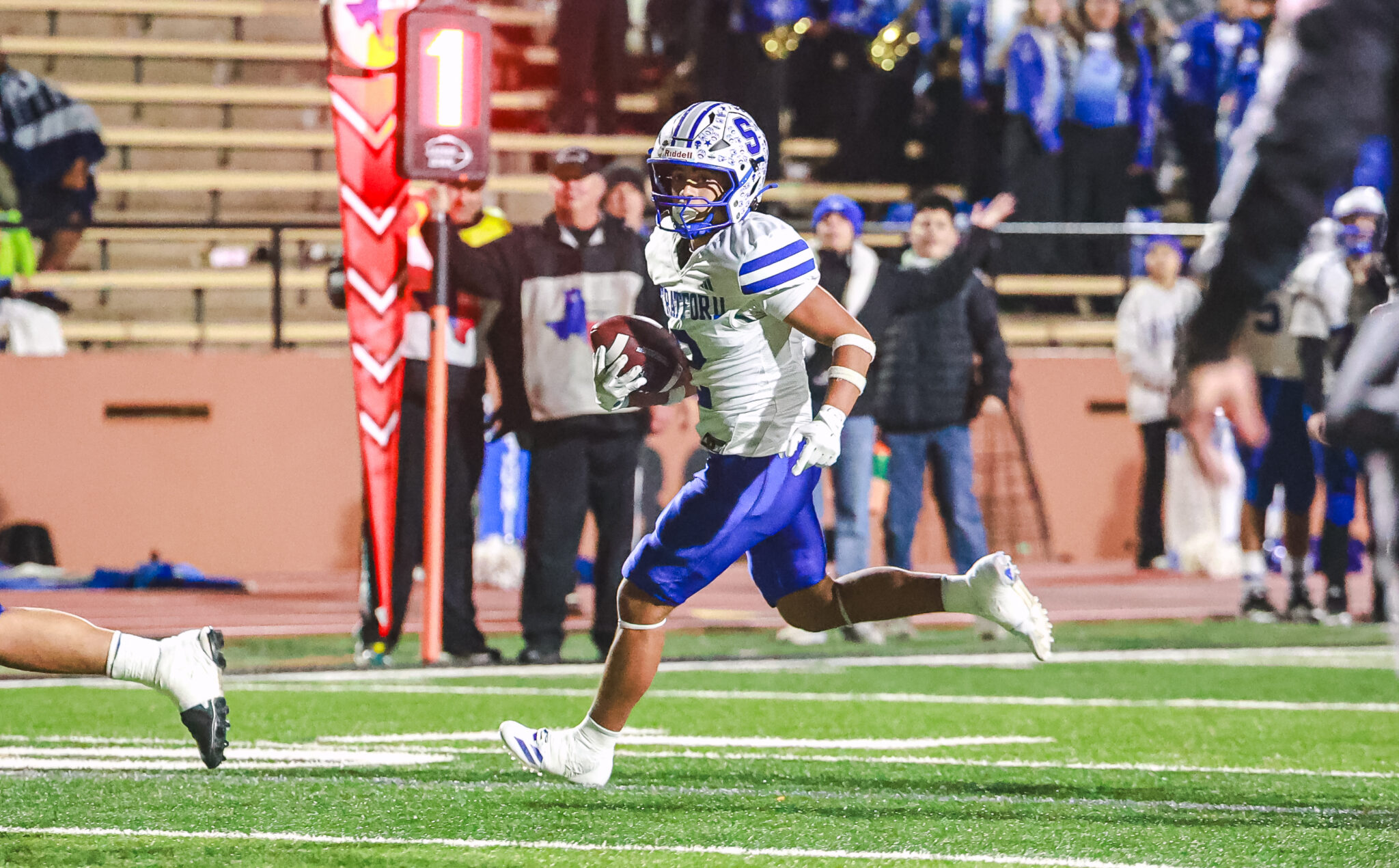 MY4A6682 1 | Press Pass Sports Football player in white and blue uniform sprinting with the ball toward the end zone on the sideline.