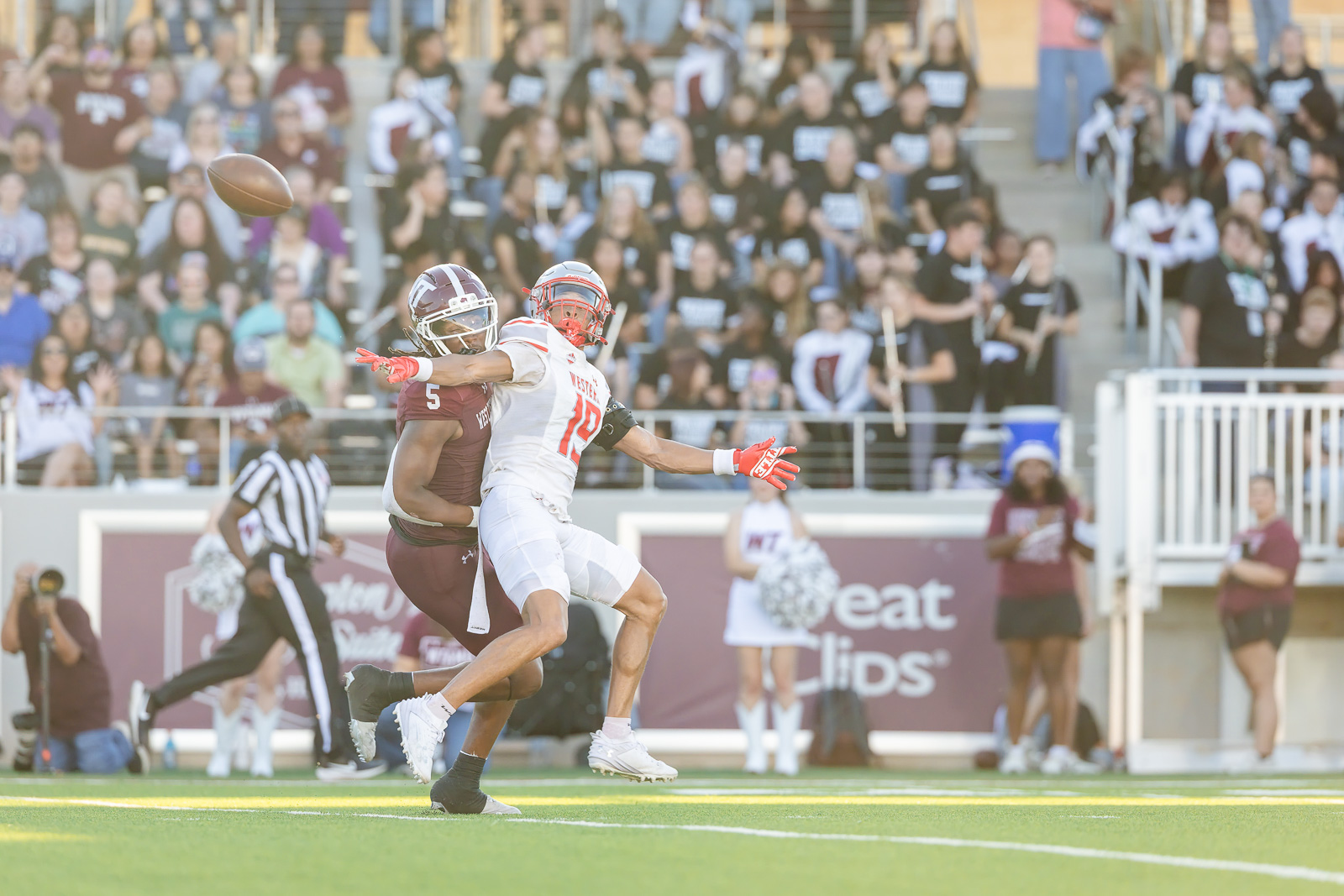 western-colorado-vs-wtamu-jpegJoe-pps-10 | Press Pass Sports Football game action: two players collide as the ball sails through the air, crowd cheering in the stands behind them.