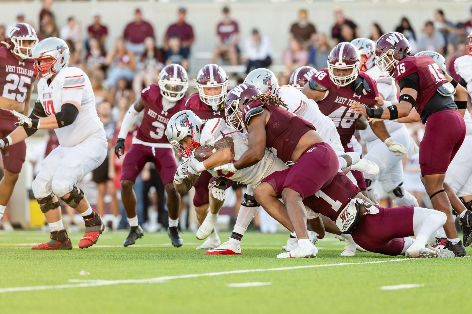 western-colorado-vs-wtamu-jpegJoe-pps-26 | Press Pass Sports West Texas A&M players swarm to tackle a ball carrier on a football field during a game (action scene).