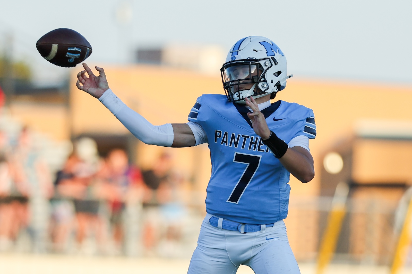 Seabolt Chase-14805 | Press Pass Sports Quarterback in a light blue Panthers jersey (#7) throwing a football on a sunny field.