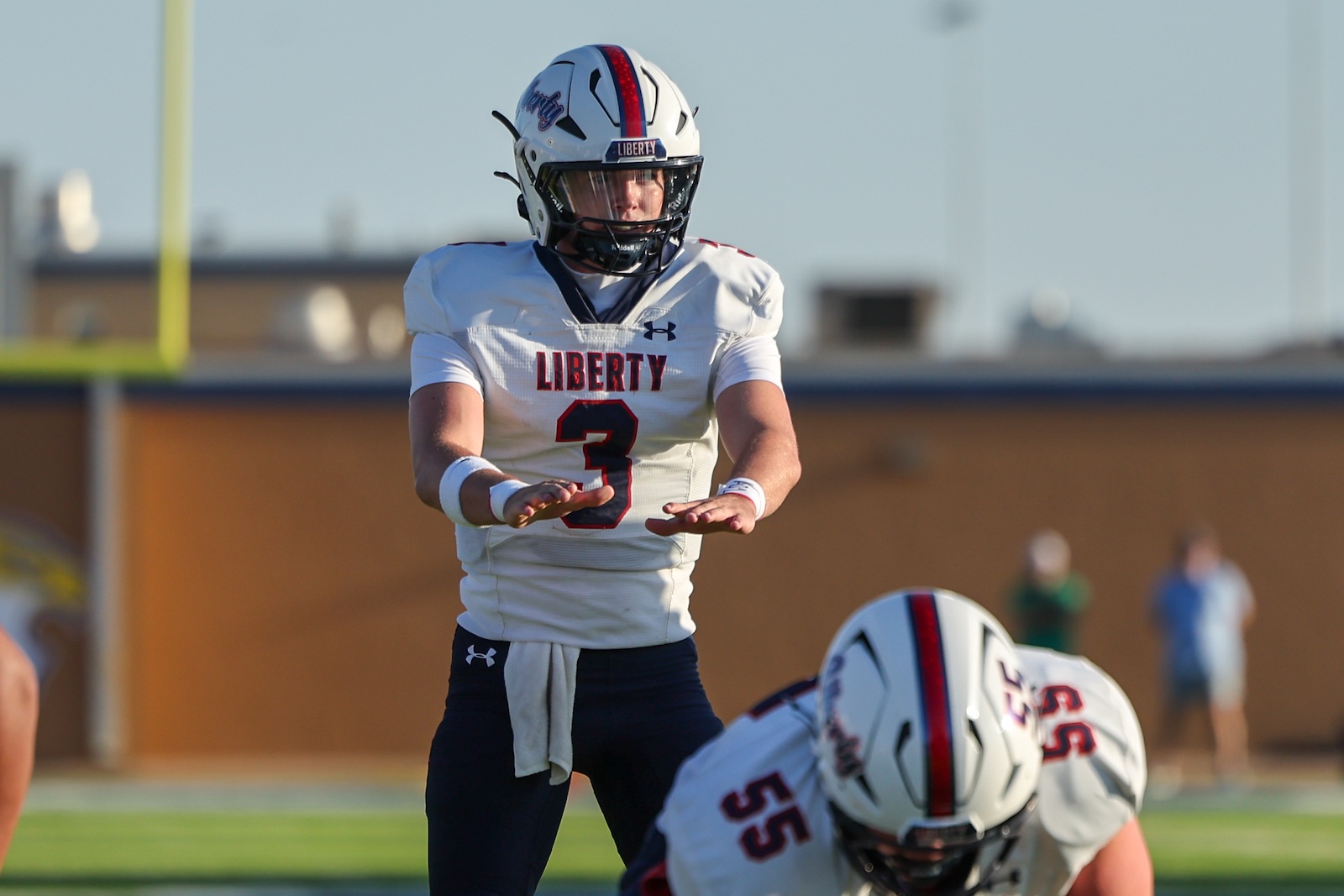 Seabolt Chase-24491 | Press Pass Sports Football player wearing Liberty jersey #3 on the field, helmet on, preparing to block or tackle during a game.
