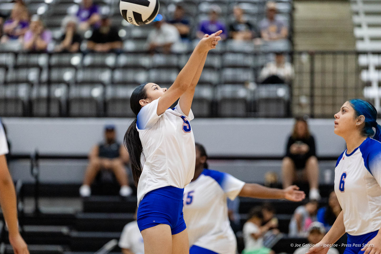 randall-showcase-2026-jpegJoe-pps-16 | Press Pass Sports Female volleyball player in white jersey and blue shorts jumps to set the ball during an indoor match.