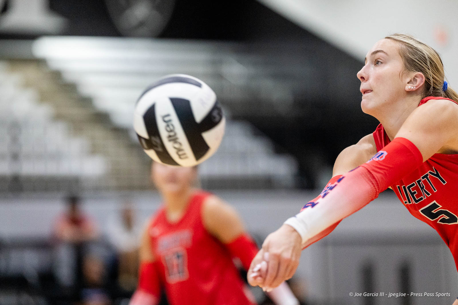 randall-showcase-2026-jpegJoe-pps-37 | Press Pass Sports Female volleyball player in a red uniform dives to hit a white-and-black ball during a match on an indoor court.