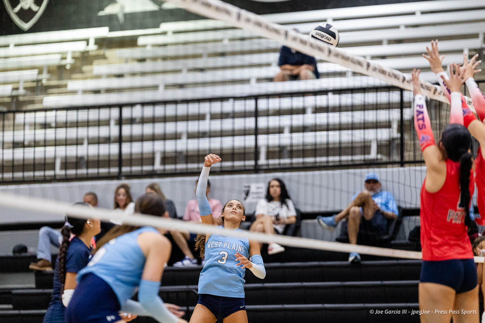 randall-showcase-2026-jpegJoe-pps-42 | Press Pass Sports West Plains player #3 in light blue jersey raises her arm to hit the ball near the net during a volleyball match.