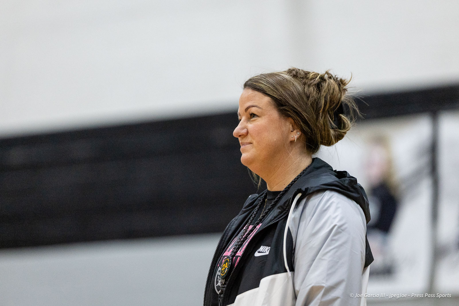randall-showcase-2026-jpegJoe-pps-63 | Press Pass Sports Side profile of a woman with a braided bun wearing a black and gray Nike jacket in a gym.