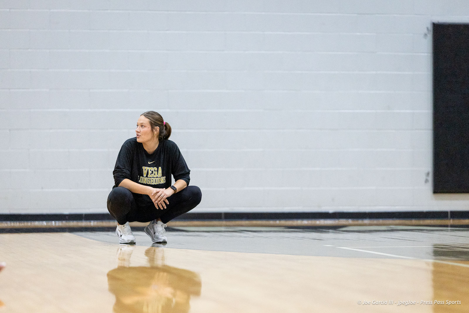 randall-showcase-2026-jpegJoe-pps-71 | Press Pass Sports Athlete crouching on a gym floor in a black Vega shirt, looking to the side.