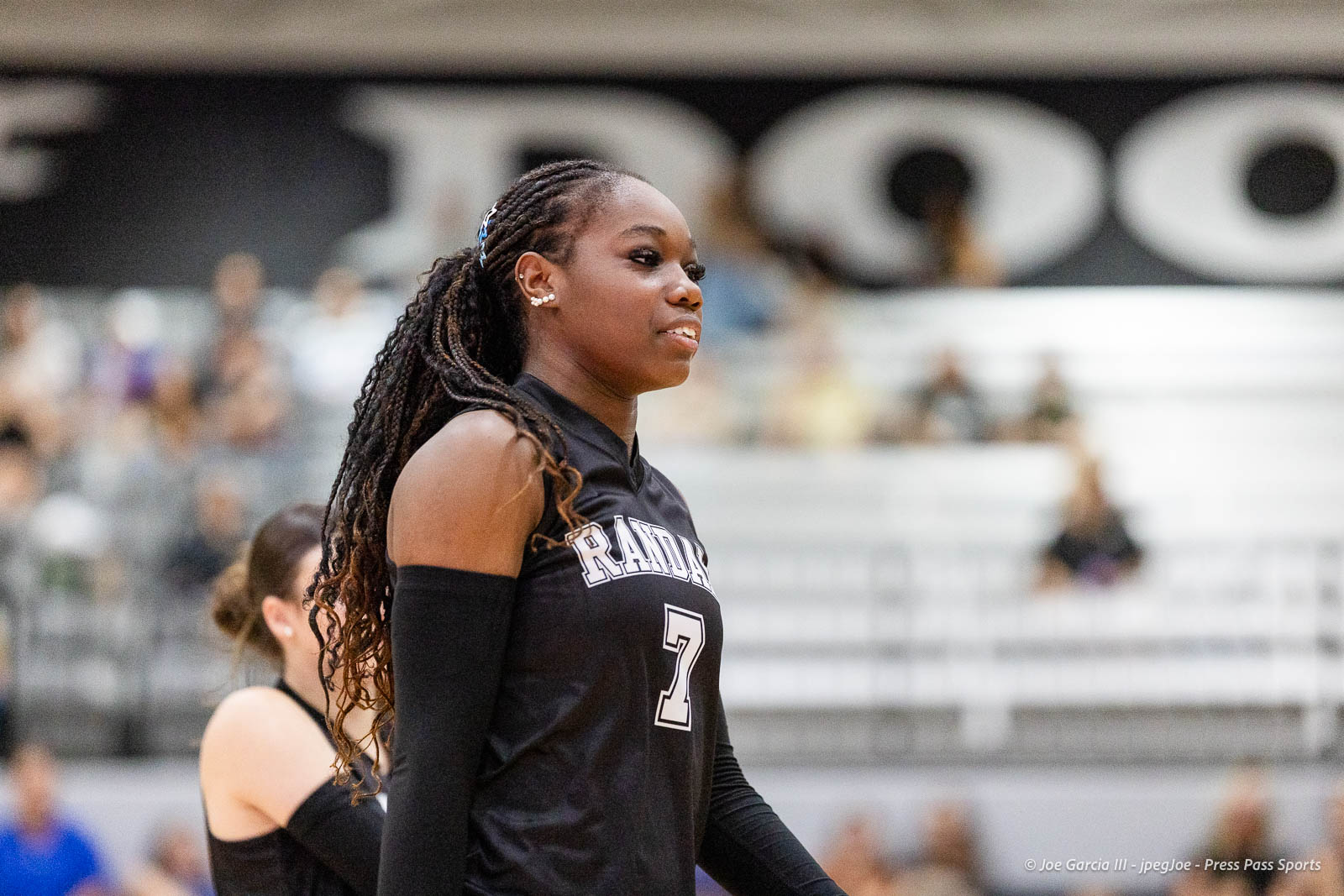 randall-showcase-2026-jpegJoe-pps-75 | Press Pass Sports Side-profile of a Black female volleyball player in a black jersey with the number 7, standing on a gym court during a match.