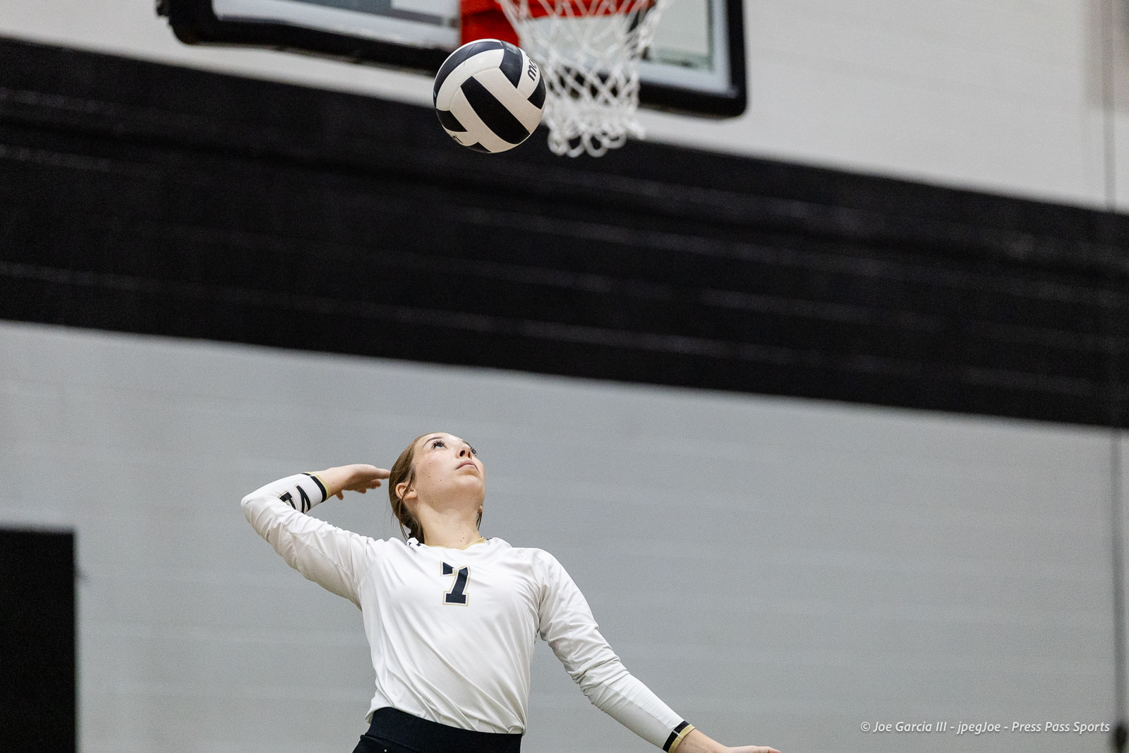 randall-showcase-2026-jpegJoe-pps-76 | Press Pass Sports Female volleyball player in a white jersey with number 1 looks up as a volleyball approaches the hoop in an indoor gym.