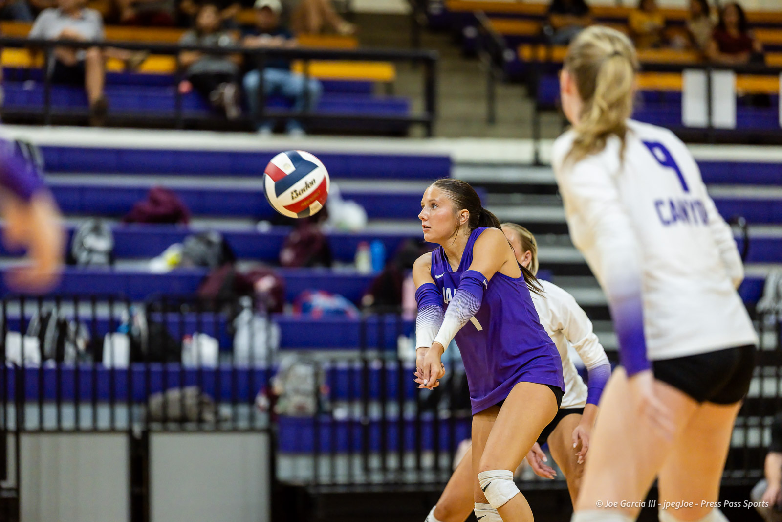 herford-vs-canyon-volleyball-jpegJoe-pps-19 | Press Pass Sports Volleyball action in a gym: a player in a purple uniform reaches for the ball as teammates defend.