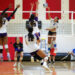 Edit 3 | Press Pass Sports Hard spike at the net by a player in white jersey as opponents block at the net; teammates nearby on the court.
