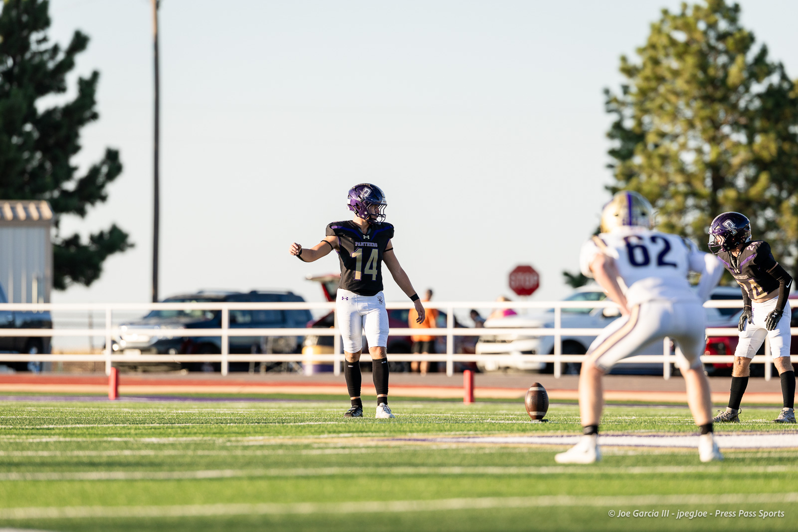 dalhart-vs-panhandle-football-jpegJoe-pps-4 | Press Pass Sports Football game scene: player in black jersey number 14 stands on the kickoff line, preparing to kick as opponents line up nearby on a sunny field