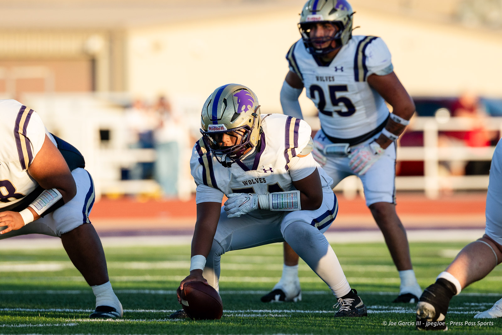 dalhart-vs-panhandle-football-jpegJoe-pps-18 | Press Pass Sports Wolves offensive lineman crouches over the ball on a bright football field, ready to snap.