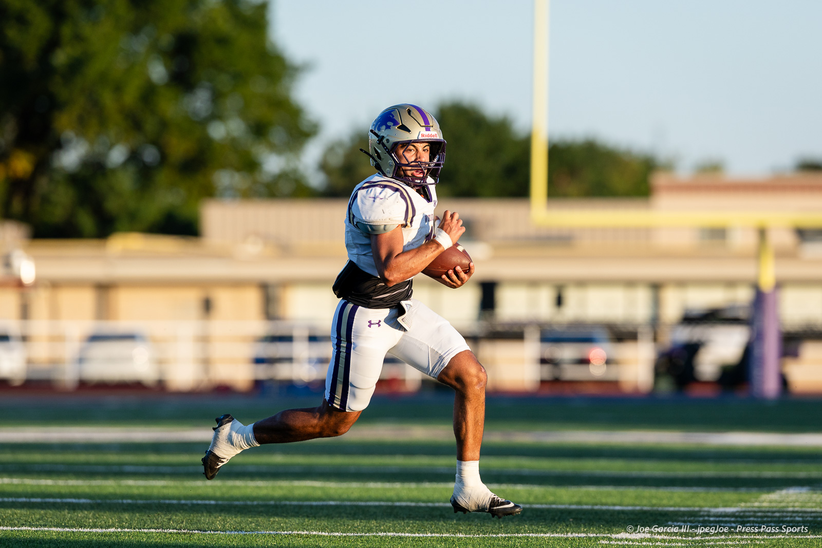 dalhart-vs-panhandle-football-jpegJoe-pps-19 | Press Pass Sports Football player in a white uniform carrying a football, sprinting on a green field during a game