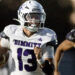 Dimmitt vs Muleshoe - Kaden Carpio | Press Pass Sports Football player in white Dimmit jersey (#23) runs with the ball, helmet on, during a game with a black-uniform opponent in the background