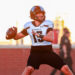 Hendrix Funk 02 | Press Pass Sports Football quarterback in white jersey (#13) holding ball, about to pass on a sunny sideline field.
