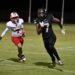 image9 5 | Press Pass Sports Two football players sprint on a night game; one in white West Texas uniform (#7) chased by a Black Mustangs player (#7).