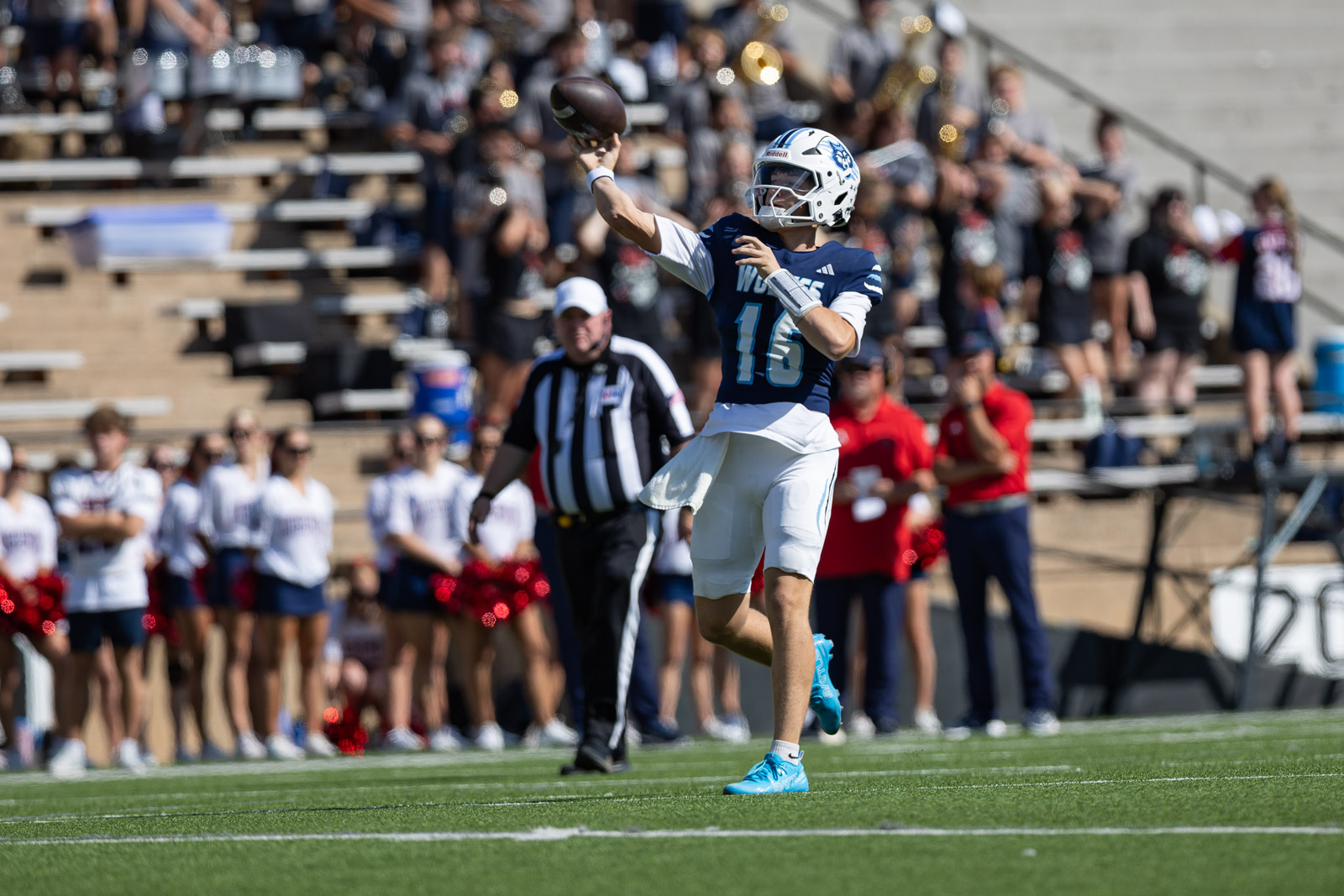 LHS-WPHS-FB-15 | Press Pass Sports Quarterback in blue jersey #16 mid-throw on a football field with a crowd and referee in the background.