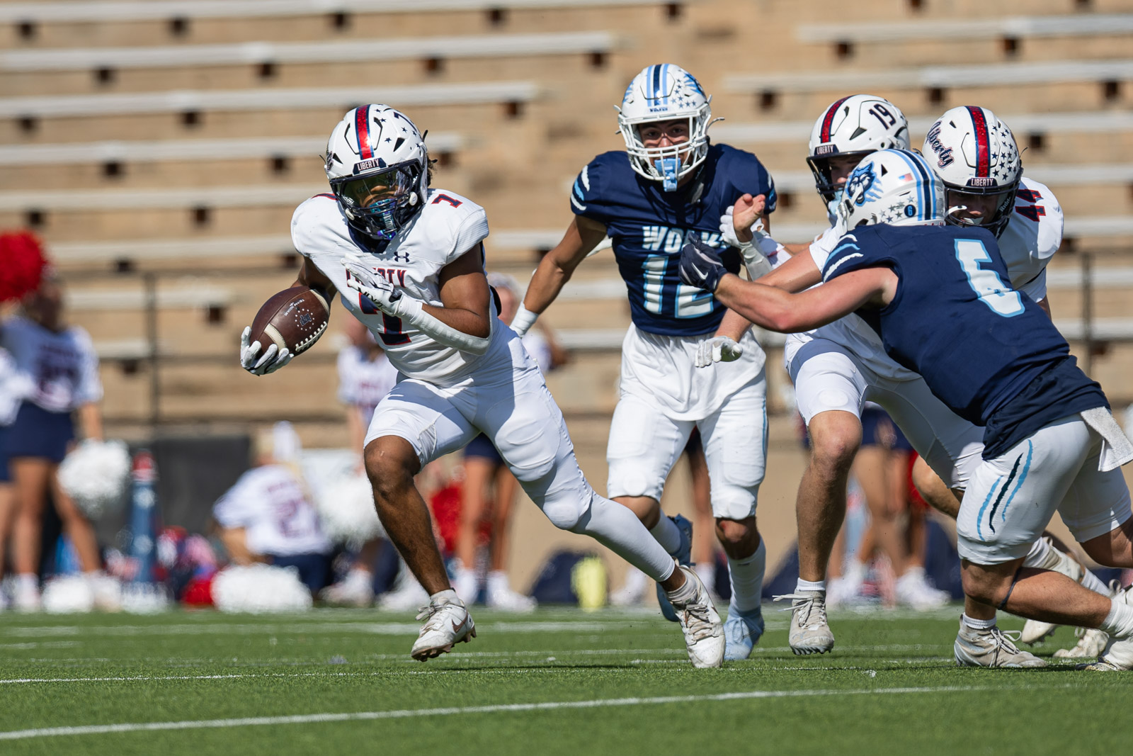 LHS-WPHS-FB-18 | Press Pass Sports Football player in a white uniform carries the ball toward the left while defenders in blue pursue.
