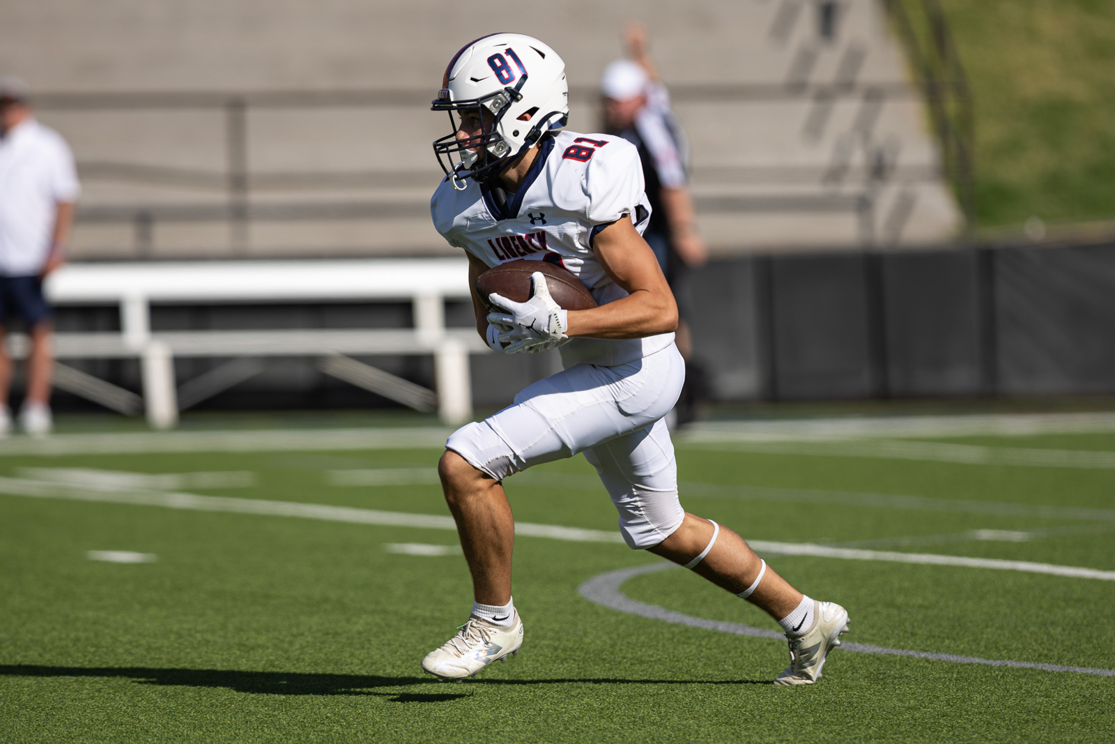 LHS-WPHS-FB-38 | Press Pass Sports Football player in white uniform #81 runs with ball during a game on a green turf field.