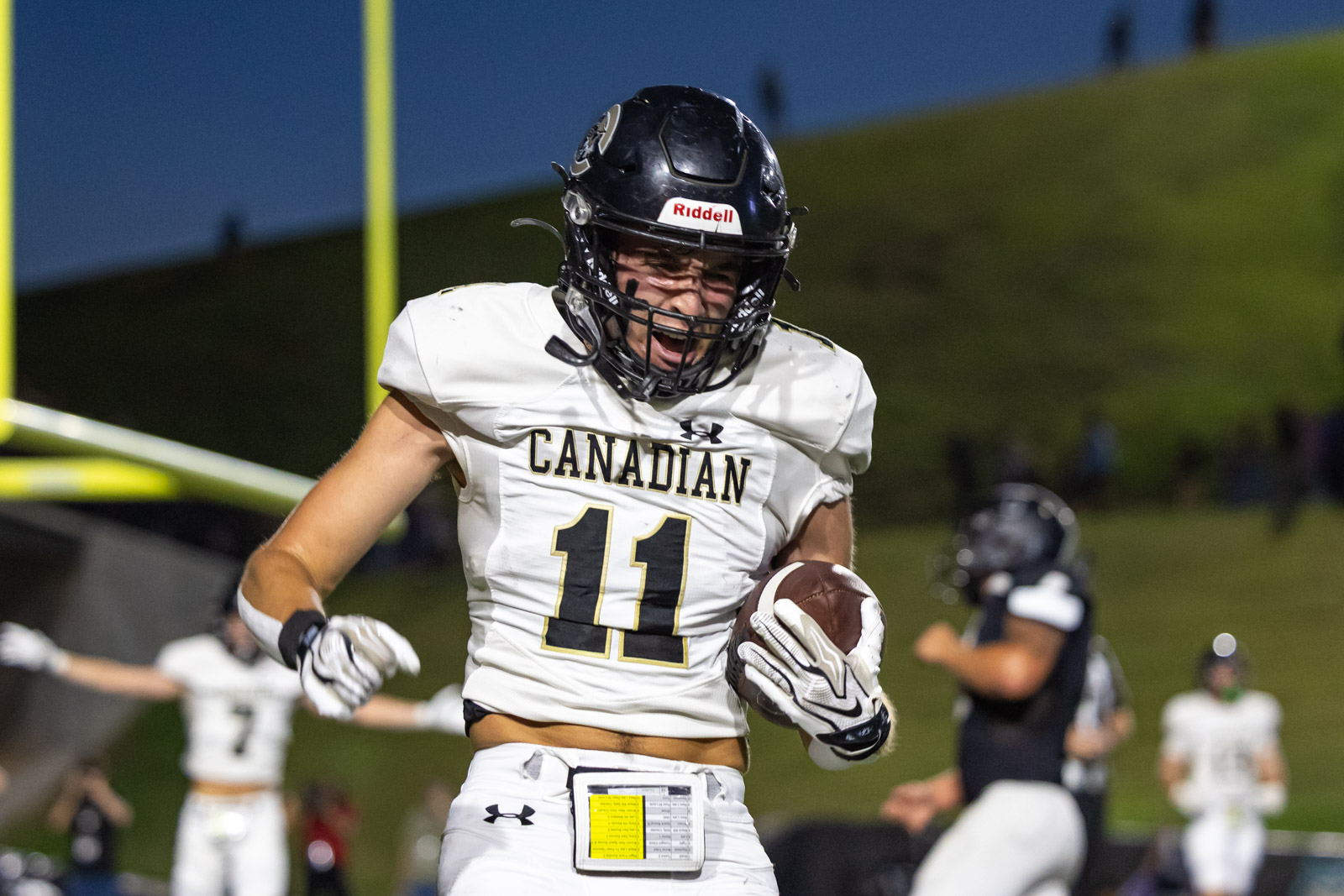 CHS-RHS-FB-21 | Press Pass Sports Football player in a white Canadian jersey with number 11 runs with the ball on a nighttime field.