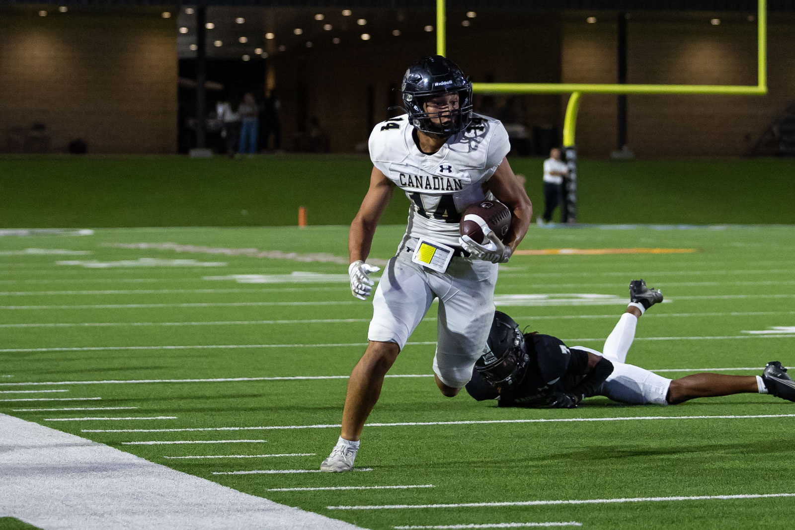 CHS-RHS-FB-34 | Press Pass Sports Canadian football player in white jersey runs with the ball toward the end zone as a defender dives behind him