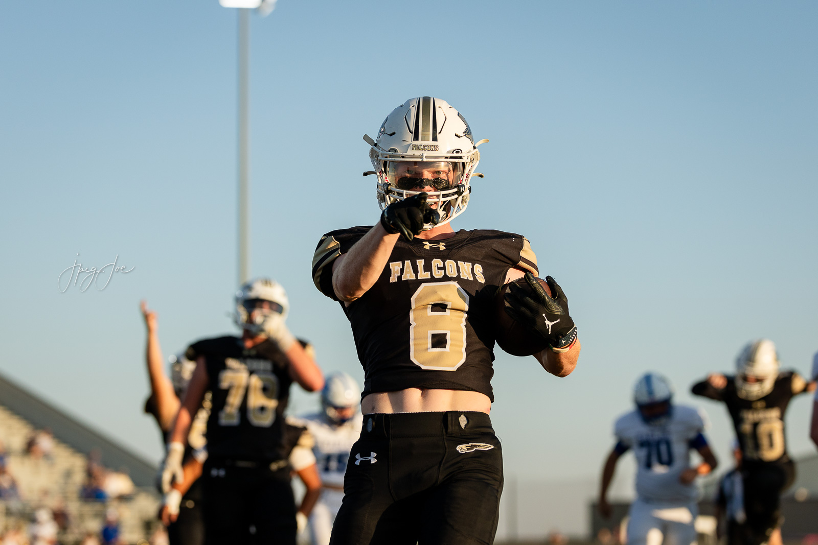lubbock-christian-vs-bushland-football-jpegJoe-12 | Press Pass Sports Football player in black Falcons uniform #6 pointing toward the camera during a game moment on the field.