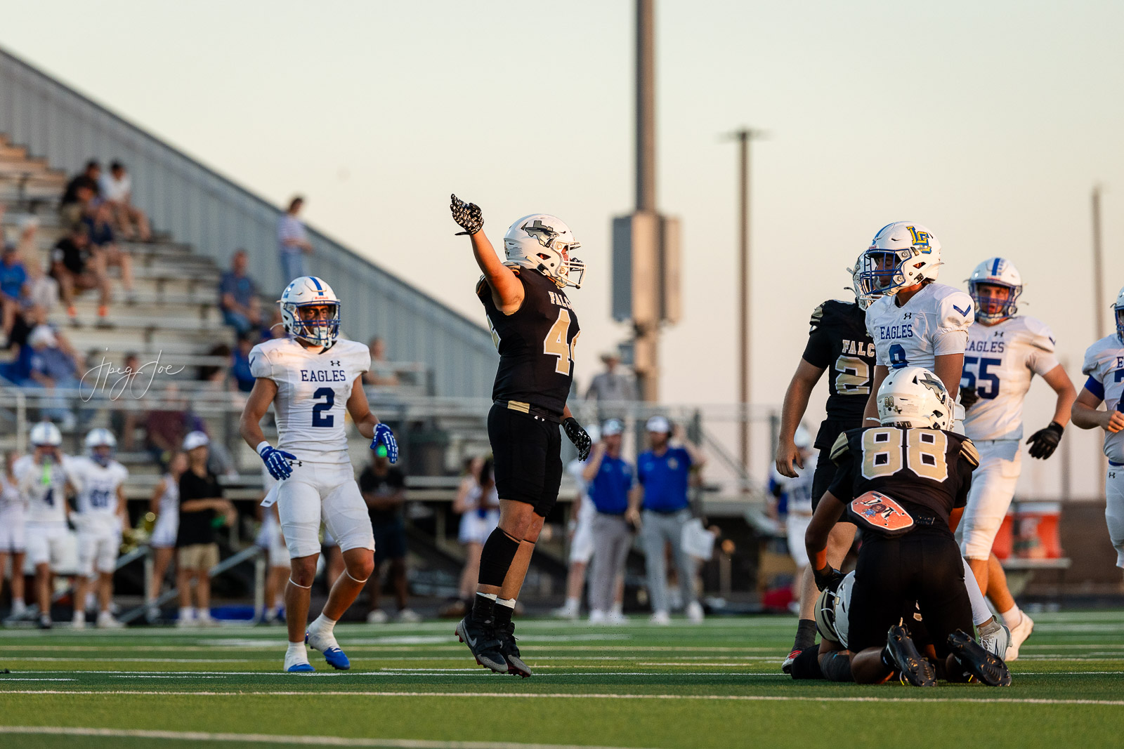 lubbock-christian-vs-bushland-football-jpegJoe-22 | Press Pass Sports Football game in progress: Black team player #41 celebrates with raised arms as White Eagles players look on.