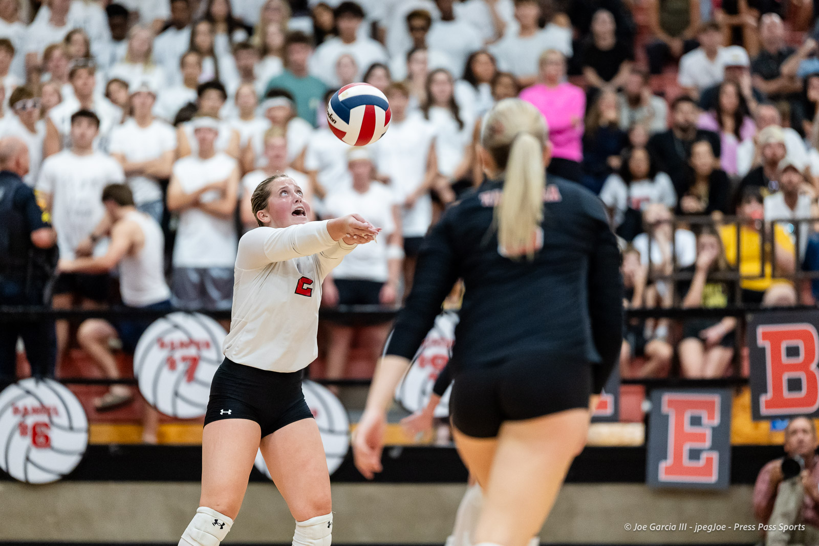 amarillo-high-vs-tascosa-volleyball-jpegJoe-pps-20 | Press Pass Sports Volleyball player in a white jersey dives forward, reaching for a ball as a large crowd watches from the bleachers behind her.