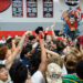 amarillo-high-vs-tascosa-volleyball-jpegJoe-pps-26 | Press Pass Sports Crowd of students cheering and raising hands in a gym during a pep rally, with red wall padding and banners in the background.