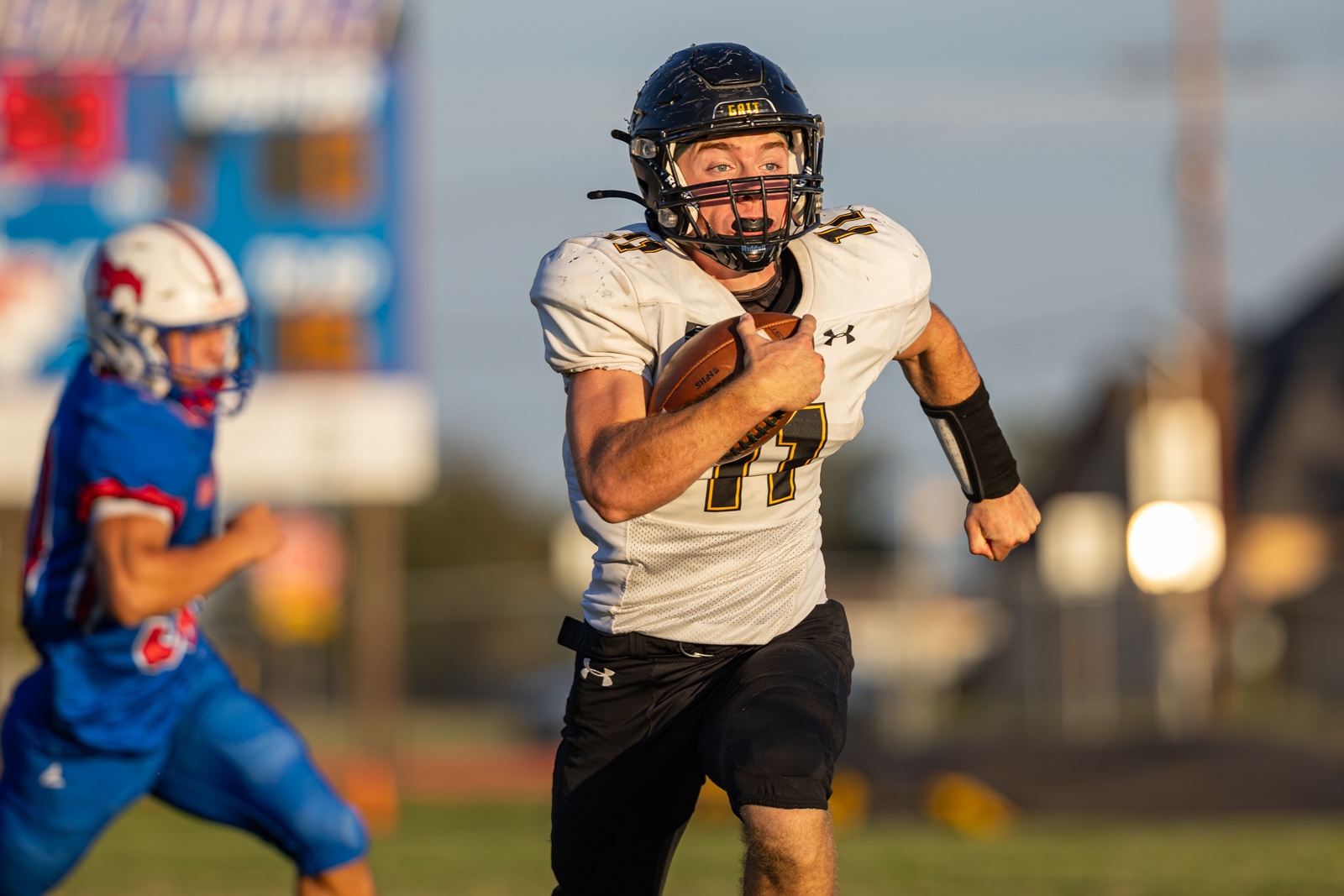 Liberty_15-10 | Press Pass Sports Football player in a white jersey with the number 17, black helmet, running with the ball during a game.