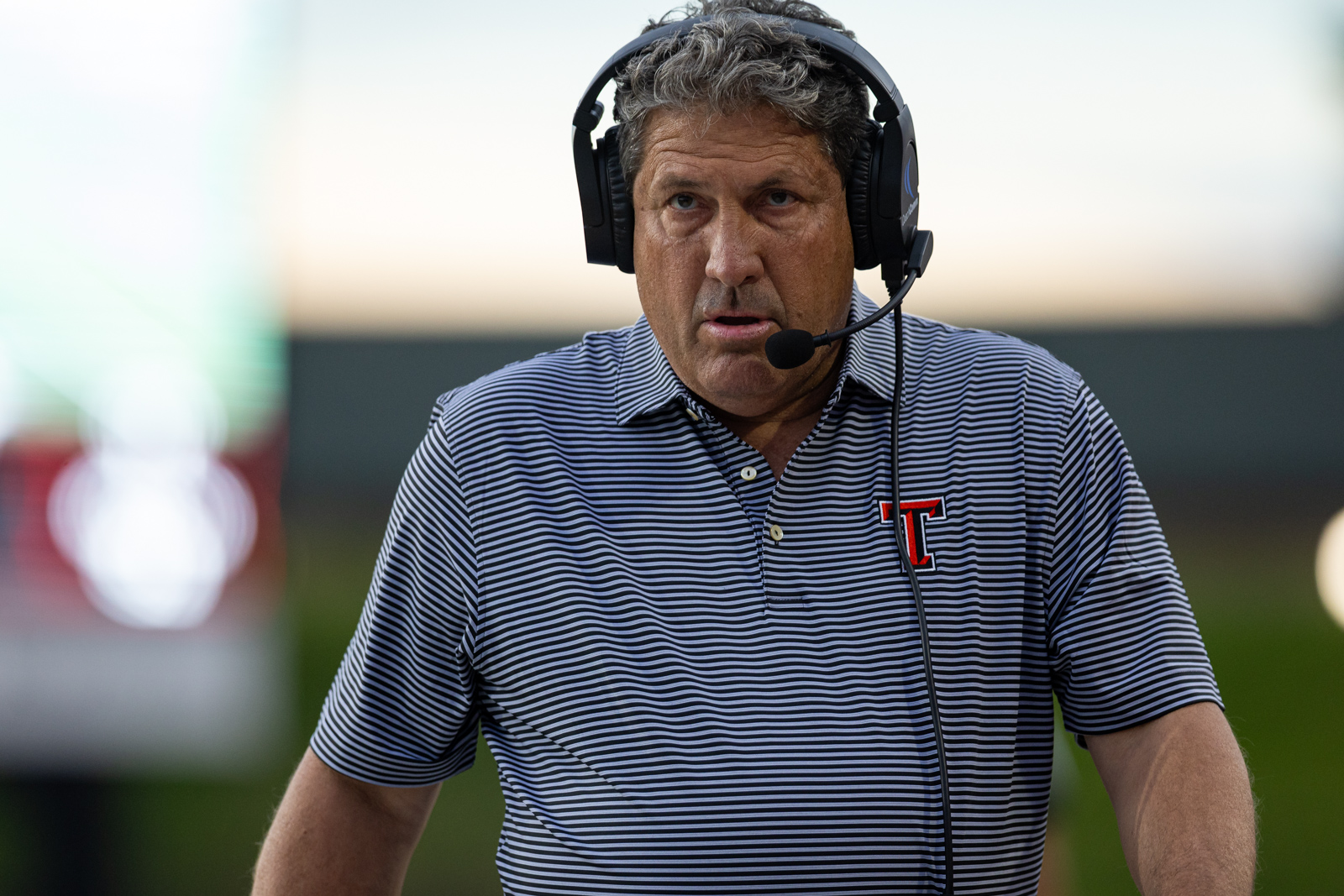 012A5456 | Press Pass Sports Man with a headset and microphone speaking, looking focused as if broadcasting.
