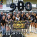 20260926-Dalhart-Bushland-VB-044 | Press Pass Sports Girls' volleyball team poses in a gym holding a banner that says 'Coach Jason Culpepper 900 Career Wins' with large black '900' balloons behind them, celebrating.