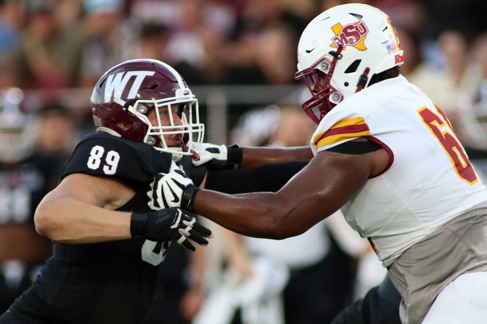 Two college football players collide in a tackle: a black-uniformed player #89 meets a white-uniformed opponent wearing a MTSU helmet.